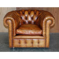 a brown leather chair sitting on top of a wooden floor