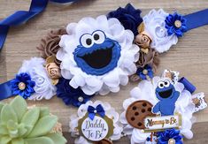 three cookie cookies decorated with royal blue and white flowers are on a table next to a succulent plant