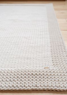 a white rug is laying on the floor in front of a wooden flooring board