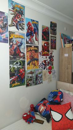 a bedroom with spiderman posters on the wall and toys in front of it's bed