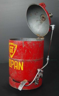 an old red metal bucket with a light on top