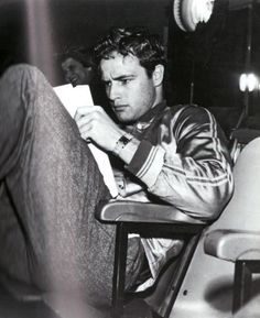 a man sitting in a chair with his legs crossed and looking at something off to the side