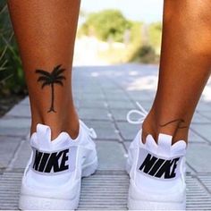 a woman's foot with a palm tree tattoo on her left side and the word nike written in black ink