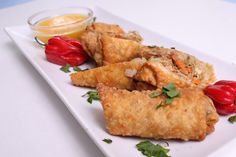 some fried food on a white plate with ketchup