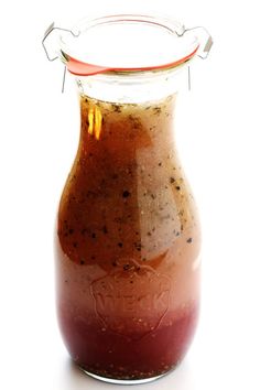 a glass jar filled with sauce on top of a white table