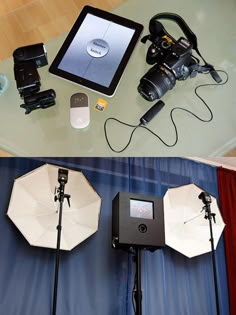 there are three cameras and two umbrellas on the table