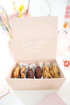 a box filled with assorted pastries sitting on top of a white countertop