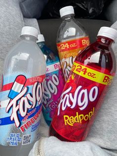 three bottles of soda and water sitting in the back seat of a car