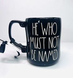 a black coffee mug with the words he who must not be named written on it