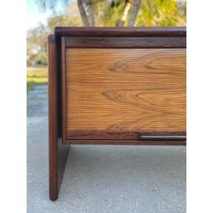 a close up of a wooden table with one drawer on the bottom and two drawers on the top