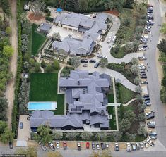 an aerial view of a large house with cars parked in the driveway and parking lot