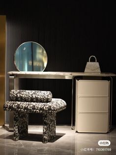 a table with a mirror, stool and other items on display in front of it