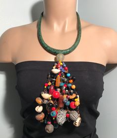 "Immerse yourself in the rich tapestry of African culture with our handmade necklace. Crafted with meticulous detail, this piece showcases traditional craftsmanship, vibrant colors, and intricate beadwork. Each bead tells a story, making this necklace not just an accessory but a cultural statement. Embrace the spirit of Africa and adorn yourself with a unique piece that reflects heritage and style. Perfect for those who appreciate the artistry and diversity of African jewelry." Material: Glass b Eclectic Multicolor Beads For Festival, Eclectic Multicolor Festival Beads, Handmade Beaded Necklaces For Festivals, Bohemian Bib Necklace With Adjustable Round Beads, Bohemian Multicolor Bib Necklace With Large Beads, Adjustable Bohemian Bib Necklace With Round Beads, Adjustable Eclectic Beaded Necklace, Handmade Green Bohemian Beaded Necklaces, Handmade Green Beaded Necklaces For Festivals