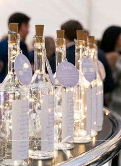 wine bottles with labels on them are sitting on a table in front of some people