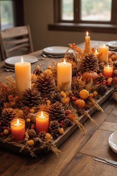 a wooden table topped with candles and pine cones