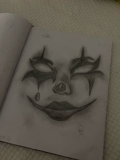 an open book with a drawing of a clown's face