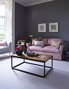 a living room with two couches, a coffee table and pictures on the wall