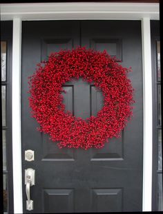 a black door with a red wreath on it