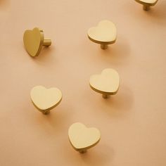 several wooden heart shaped knobs on a beige surface