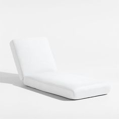 a white chaise lounge chair on a plain surface with no one sitting in it