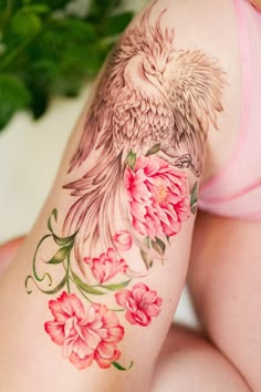 a woman's thigh with flowers and a bird on it