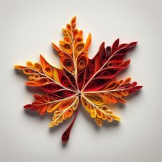 a colorful leaf made out of paper sitting on top of a white surface with red, yellow and orange leaves