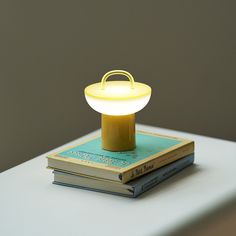 a yellow table lamp sitting on top of two books