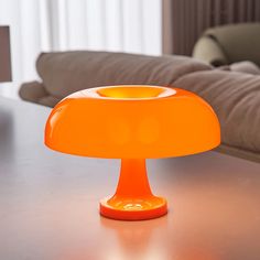 an orange lamp sitting on top of a table