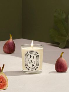 a candle sitting on top of a table next to figurines and a leaf