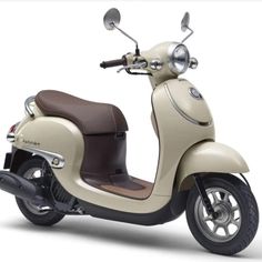 a white scooter with brown leather seats on the front and back seat,