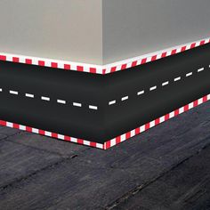 an image of a road going down the side of a building that is painted red and white