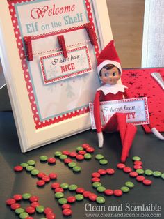 an elf is sitting next to a welcome sign