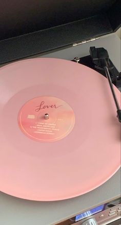 a pink record player sitting on top of a table