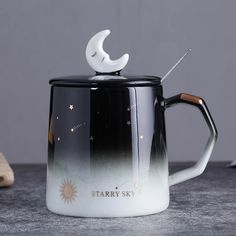 a black and white coffee mug with stars on the inside, sitting on a table