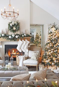 a living room decorated for christmas with stockings and candles on the fireplace mantels