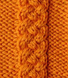 an orange knitted sweater with braiding on the bottom and side, close up