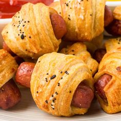 hot dogs wrapped in croissants on a plate with ketchup and mustard