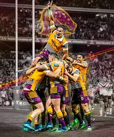 a group of men standing on top of each other in front of a stadium filled with people