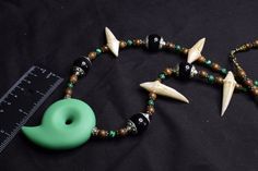 This necklace was inspired by Japanese Culture and Anime Culture. It features a Green Resin Magatama Focal and Resin Dragon Teeth. There are Genuine Malachite, Faint Rainbow Obsidian, and Wood beads featured around the necklace. It is about 34" long and strung on 49 strand nylon coated stainless steel wire. Dragon Priestess, Fantasy Amulet, Dragon Teeth, Resin Dragon, Rainbow Obsidian, Teeth Jewelry, Stainless Steel Wire, Japanese Culture, Fort Worth