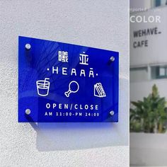 a blue sign on the side of a building next to a planter filled with flowers