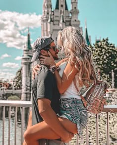 a man and woman kissing in front of a castle