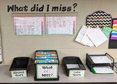 a desk topped with lots of binders and boxes filled with papers next to a bulletin board that says what did i miss?