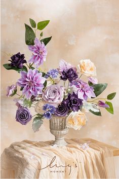 a vase filled with lots of purple and white flowers