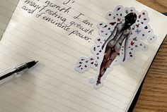 a notepad with an image of a woman's body on it next to a pen