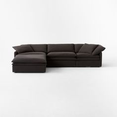 a black sectional couch sitting on top of a white floor