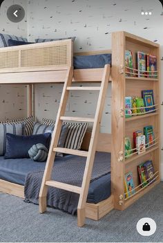 a wooden bunk bed with bookshelves and pillows on the bottom shelf in a child's bedroom