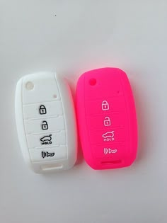 two pink and white car keys sitting next to each other