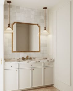 a bathroom with two sinks and a large mirror on the wall next to white cabinets