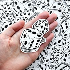 a hand holding a pair of dice stickers