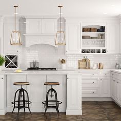 a white kitchen with two stools in front of the counter